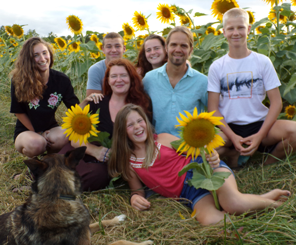 Photo de la famille de Véronique et Sébastien dans un champ de tournesols