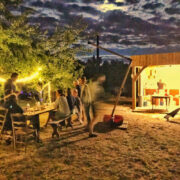 Photo de la cuisine d'été et de la grande table avec des personnes prenant leur repas